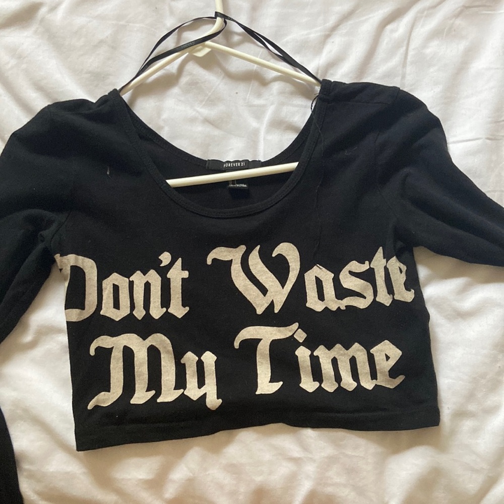 Black long sleeve crop top says “don’t waste my time” in front, from Forever 21